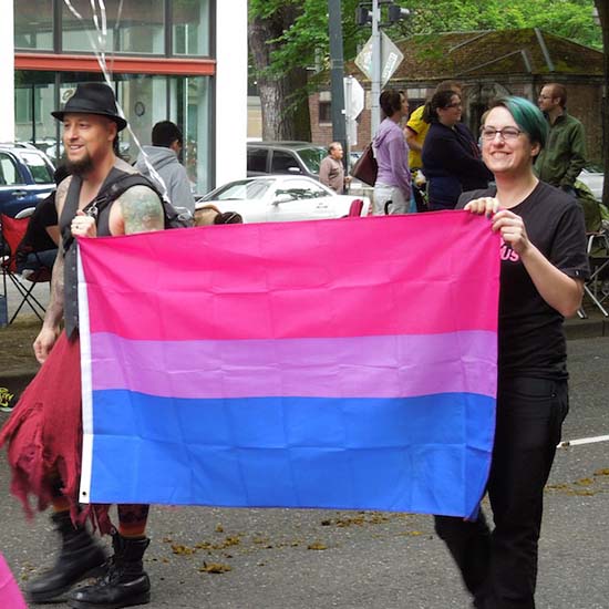 Picture        06/25/14 Bi Brigade members proudly show off the Bi Pride flag